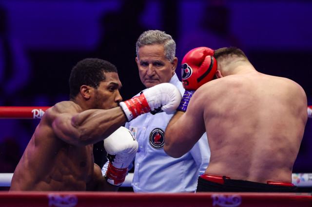 Britain's Anthony Joshua (L) and Albania's Kristian Prenga (R) trade blows during their heavyweight boxing fight at the Jeddah Superdome in Jeddah on July 26, 2026. Two-time heavyweight world champion Anthony Joshua survived two early knockdowns on the way to a second-round knockout of Kristian Prenga on July 26, his triumphant ring return paving the way for a blockbuster all-British bout with Tyson Fury. (Photo by AFP)