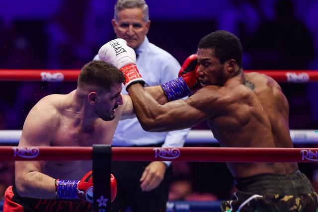 Britain's Anthony Joshua (R) and Albania's Kristian Prenga (L) trade blows during their heavyweight boxing fight at the Jeddah Superdome in Jeddah on July 26, 2026. Two-time heavyweight world champion Anthony Joshua survived two early knockdowns on the way to a second-round knockout of Kristian Prenga on July 26, his triumphant ring return paving the way for a blockbuster all-British bout with Tyson Fury. (Photo by AFP)