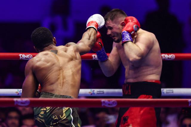 Britain's Anthony Joshua (L) and Albania's Kristian Prenga trade blows during their heavyweight boxing fight at the Jeddah Superdome in Jeddah on July 26, 2026. Two-time heavyweight world champion Anthony Joshua survived two early knockdowns on the way to a second-round knockout of Kristian Prenga on July 26, his triumphant ring return paving the way for a blockbuster all-British bout with Tyson Fury. (Photo by AFP)