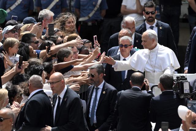 Pope Leo XIV greets the crowd after the Angelus prayer from the entrance of the Apostolic Palace in Piazza della Liberta (Liberty Square) at the summer papal residence in Castel Gandolfo on July 26, 2026. (Photo by TIZIANA FABI / AFP)