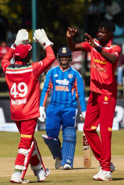 Zimbawe's Blessing Muzarabani (R) celebrates with Zimbabwe's Tadiwanashe Marumani (L) the wicket of Abhisheck Sharma during the third Twenty20 international cricket match between Zimbabwe and India at Harare Sports Club in Harare, on July 26, 2026. (Photo by Jekesai NJIKIZANA / AFP)