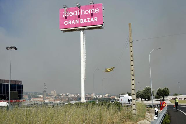 An Air Tractor AT-802F Fire Boss aircraft is pictured as a fire started in an industrial area of San Martin de Valdeiglesias, about 70km west of Madrid, on July 26, 2026. In the western Madrid region, two separate wildfires merged on July 24 into a massive blaze that nearly joined another fire in neighboring Castile and Leon. The flames have already burned 25,000 hectares across Madrid and neighboring Avila province, forcing more than 60,000 people to flee their homes, according to authorities, who labeled the fire the "worst in history" for the Madrid region. (Photo by Oscar DEL POZO / AFP)