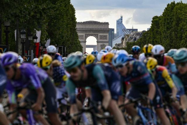 The pack of riders (peloton) cycles on the Avenue des Champs-Elysees during the 21st stage of the 113th edition of the Tour de France cycling race, 88,7 km starting and finishing in Paris, on July 26, 2026. (Photo by Jeff PACHOUD / AFP)