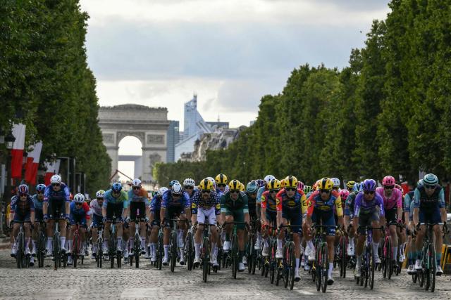 The pack of riders (peloton) cycles on the Avenue des Champs-Elysees during the 21st stage of the 113th edition of the Tour de France cycling race, 88,7 km starting and finishing in Paris, on July 26, 2026. (Photo by Jeff PACHOUD / AFP)