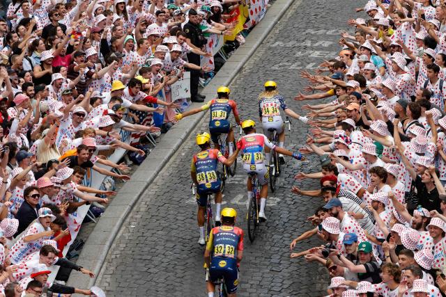 The pack of riders (peloton) cycles up Rue Lepic on the ascent of the Butte de Montmartre during the 21st stage of the 113th edition of the Tour de France cycling race, 88,7 km starting and finishing in Paris, on July 26, 2026. (Photo by GEOFFROY VAN DER HASSELT / AFP)