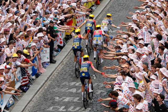 The pack of riders (peloton) cycles up Rue Lepic on the ascent of the Butte de Montmartre during the 21st stage of the 113th edition of the Tour de France cycling race, 88,7 km starting and finishing in Paris, on July 26, 2026. (Photo by GEOFFROY VAN DER HASSELT / AFP)