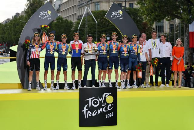Lidl - Trek team riders celebrate their best team award on the podium after the 21st stage of the 113th edition of the Tour de France cycling race, 130 km between Thoiry and Paris in northern France, on July 26, 2026. (Photo by Anne-Christine POUJOULAT / AFP)