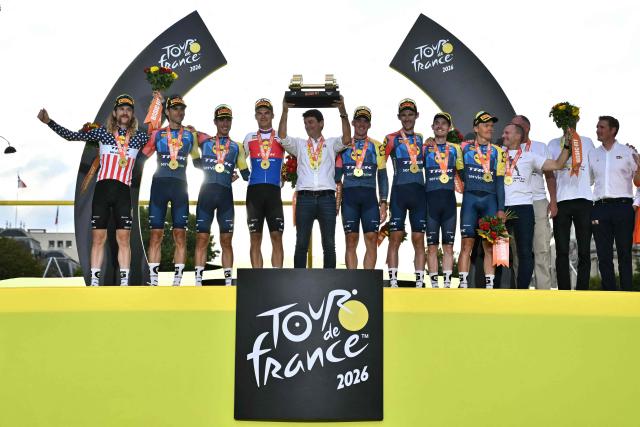 Lidl - Trek team riders celebrate their best team award on the podium after the 21st stage of the 113th edition of the Tour de France cycling race, 130 km between Thoiry and Paris in northern France, on July 26, 2026. (Photo by Jeff PACHOUD / AFP)