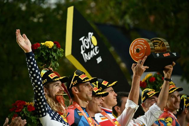 Lidl - Trek team riders celebrate their best team award on the podium after the 21st stage of the 113th edition of the Tour de France cycling race, 130 km between Thoiry and Paris in northern France, on July 26, 2026. (Photo by Loic VENANCE / AFP)