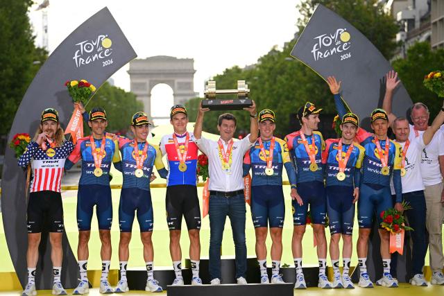 Lidl - Trek team riders celebrate their best team award on the podium after the 21st stage of the 113th edition of the Tour de France cycling race, 130 km between Thoiry and Paris in northern France, on July 26, 2026. (Photo by Bernard PAPON / POOL / AFP)