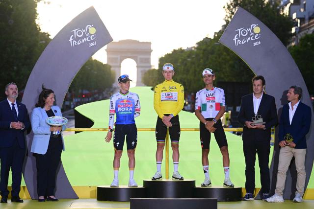 Overall winner UAE Team Emirates - XRG's Slovenian rider Tadej Pogacar celebrates on the on the podium with second-placed Red Bull - BORA - hansgrohe team's Belgian rider Remco Evenepoel and third-placed UAE Team Emirates - XRG's Mexican rider Isaac Del Toro after the 21st stage of the 113th edition of the Tour de France cycling race, 88,7 km starting and finishing in Paris, on July 26, 2026. (Photo by Bernard PAPON / POOL / AFP)