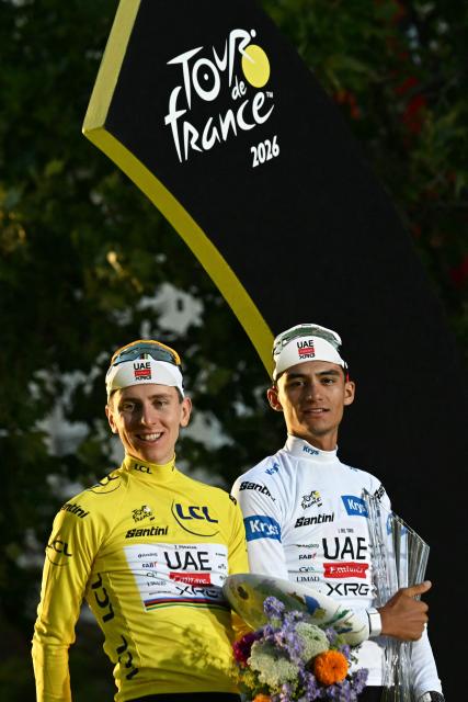 UAE Team Emirates - XRG's Slovenian rider Tadej Pogacar wearing the overall leader's yellow jersey, and UAE Team Emirates - XRG's Mexican rider Isaac Del Toro wearing the best young rider's white jersey celebrate on the podium after the 21st stage of the 113th edition of the Tour de France cycling race, 88,7 km starting and finishing in Paris, on July 26, 2026. (Photo by Loic VENANCE / AFP)