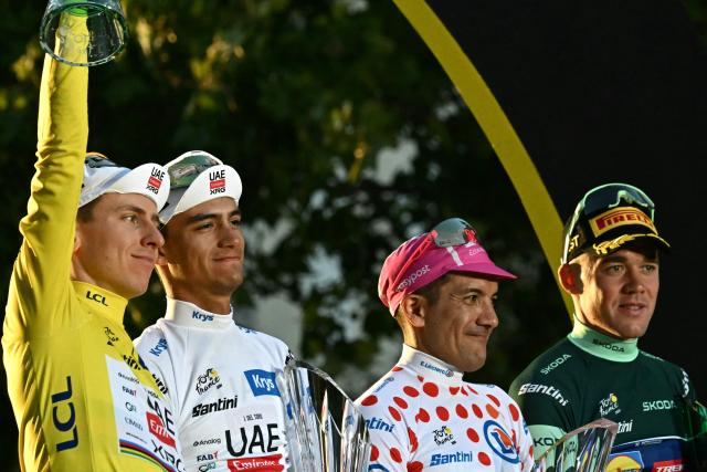 UAE Team Emirates - XRG's Slovenian rider Tadej Pogacar wearing the overall leader's yellow jersey, EF Education - EasyPost team's Ecuadorian rider Richard Carapaz wearing the climber's dotted "King of the Mountains" jersey, Lidl - Trek team's Danish rider Mads Pedersen wearing the sprinter's green jersey and UAE Team Emirates - XRG's Mexican rider Isaac Del Toro wearing the best young rider's white jersey celebrate on the podium after the 21st stage of the 113th edition of the Tour de France cycling race, 88,7 km starting and finishing in Paris, on July 26, 2026. (Photo by Loic VENANCE / AFP)
