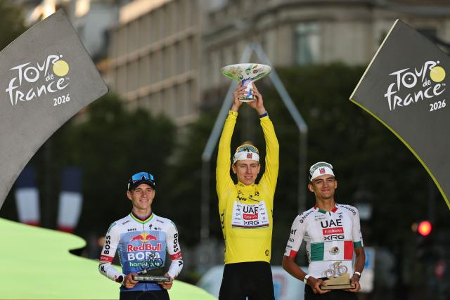 Overall winner UAE Team Emirates - XRG's Slovenian rider Tadej Pogacar celebrates on the on the podium with second-placed Red Bull - BORA - hansgrohe team's Belgian rider Remco Evenepoel and third-placed UAE Team Emirates - XRG's Mexican rider Isaac Del Toro after the 21st stage of the 113th edition of the Tour de France cycling race, 88,7 km starting and finishing in Paris, on July 26, 2026. (Photo by Anne-Christine POUJOULAT / AFP)