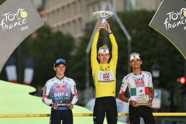 Overall winner UAE Team Emirates - XRG's Slovenian rider Tadej Pogacar celebrates on the on the podium with second-placed Red Bull - BORA - hansgrohe team's Belgian rider Remco Evenepoel and third-placed UAE Team Emirates - XRG's Mexican rider Isaac Del Toro after the 21st stage of the 113th edition of the Tour de France cycling race, 88,7 km starting and finishing in Paris, on July 26, 2026. (Photo by Anne-Christine POUJOULAT / AFP)