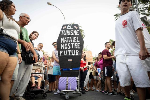 Protesters hold a banner which reads as “Tourism kills our future” during a demonstration against overtourism and housing prices in Palma de Mallorca, on the Balearic island of Mallorca, on July 26, 2026. (Photo by JAIME REINA / AFP)