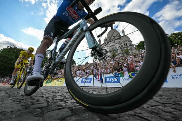 (FILES) UAE Team Emirates - XRG's Slovenian rider Tadej Pogacar wearing the overall leader's yellow jersey pursues Alpecin - Premier Tech team's Dutch rider Mathieu van der Poel as they cycle past the Sacre Coeur basilica during the 21st stage of the 113th edition of the Tour de France cycling race, 88,7 km starting and finishing in Paris, on July 26, 2026. (Photo by Loic VENANCE / AFP)
