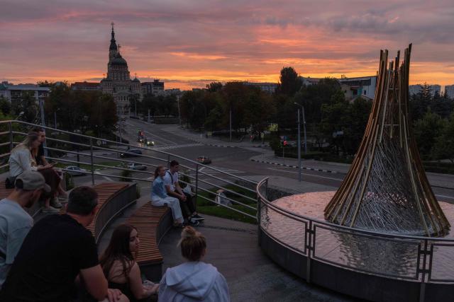 People sit at an observation area in a park with the Annunciation Cathedral in the background, in Ukraine's eastern city of Kharkiv on July 25, 2026, amid the Russian invasion of Ukraine. (Photo by Roman PILIPEY / AFP)
