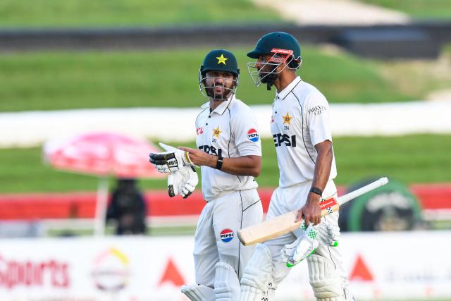 Salman Ali Agha (L) and Shan Masood (R) of Pakistan walk off the field at the end of the 2nd day of 1st Test match between West Indies and Pakistan at Brian Lara Cricket Academy in Tarouba, Trinidad and Tobago on July 26, 2026. (Photo by Randy Brooks / AFP)