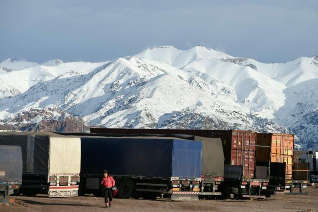 Trucks are pictured awaiting the reopening of the highway affected due to several snow storms near the Argentina-Chile border in Uspallata, Medonza province, Argentina on July 26, 2026. Snowfall is forecasted for the next few days on the Andes mountains forcing the clousure of the international road between Argentina and Chile where dozens of trucks are stranded according to local authorities. (Photo by Andres LARROVERE / AFP)
