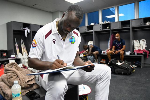 West Indies bowler Kemar Roach signs the condolence book for the late cricket legend Sir Garfield Sobers at the end of the second day of first Test cricket match between West Indies and Pakistan at the Brian Lara Cricket Academy in Tarouba, Trinidad and Tobago, on July 26, 2026. Sir Garfield Sobers, widely regarded as cricket's most outstanding all-rounder, died aged 89 on July 17, 2026, sparking a flood of tributes from all over the cricket world to the Barbadian. (Photo by Randy Brooks / AFP)