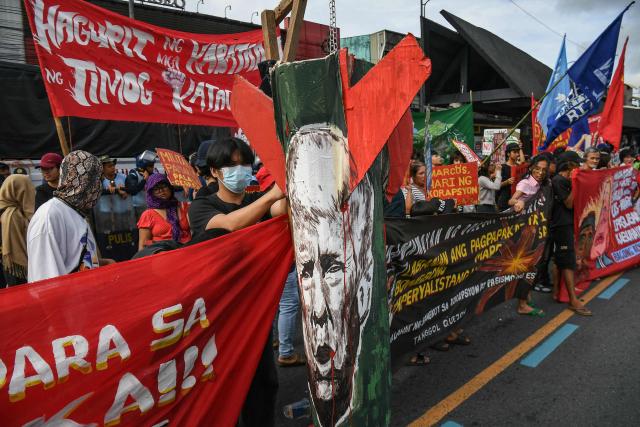 Protesters display a missile-shaped placard with an image of US President Donald Trump during a demonstration ahead of Philippine President Ferdinand Marcos’ State of the Nation Address at the House of Representatives in Quezon City, suburban Manila on July 27, 2026. (Photo by TED ALJIBE / AFP)
