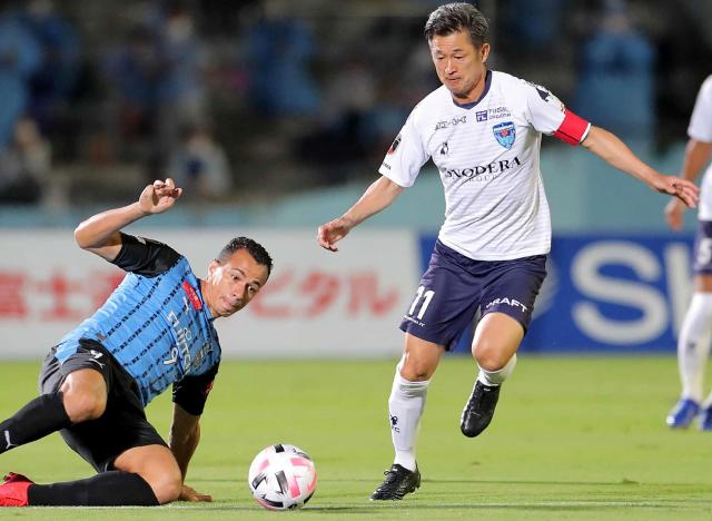 (FILES) Yokohama FC forward Kazuyoshi Miura (R) is tackled by Kawasaki Frontale forward Leandro Damiao during the J-League football match between Kawasaki Frontale and Yokohama FC at Todoroki Athletics stadium in Kawasaki on September 23, 2020. The 59-year-old former Japan striker Kazuyoshi Miura scored his first competitive goal in almost four years when his Fukushima United side strolled to a 7-0 win on July 25, 2026. (Photo by JIJI PRESS / AFP) / Japan OUT