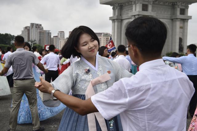 Youth and students dance at the plaza of the Arch of Triumph to mark the 73rd anniversary of the end of the Korean War in Pyongyang on July 27, 2026. (Photo by KIM Won Jin / AFP)
