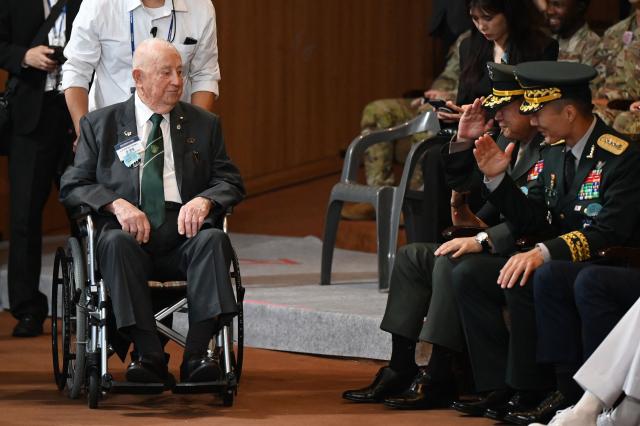Australian veteran of the Korean War John Munro is saluted by South Korean military officials as he arrives for a national ceremony for the Korean War UN Veterans Day in Seoul on July 27, 2026. (Photo by GREG BAKER / AFP)