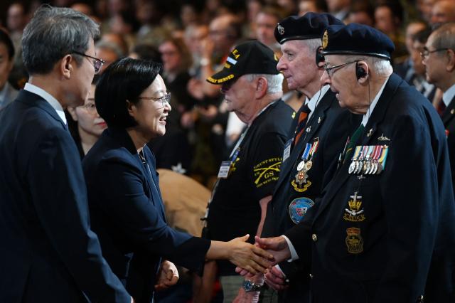 South Korean Prime Minister Han Seong-sook (C) shakes hands with Canadian veteran of the Korean War Andrew Barber during a national ceremony for the Korean War UN Veterans Day in Seoul on July 27, 2026. (Photo by GREG BAKER / AFP)