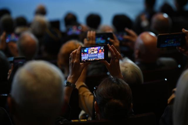 Guests record a performance during a national ceremony for the Korean War UN Veterans Day in Seoul on July 27, 2026. (Photo by GREG BAKER / AFP)