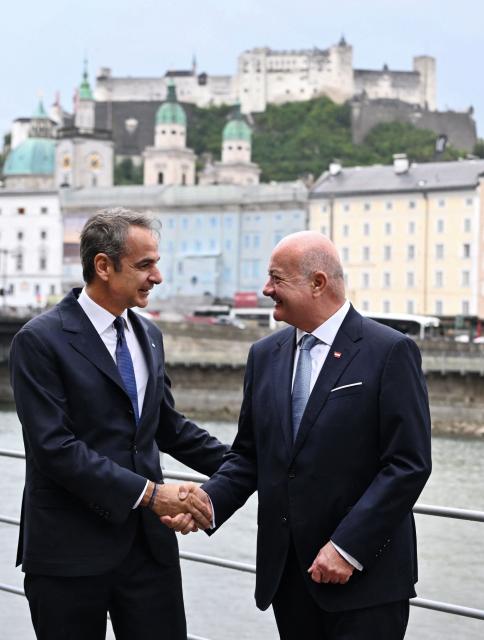 Austrian Chancellor Christian Stocker (R) welcomes Greek Prime Minister Kyriakos Mitsotakis for a meeting on the sidelines of the Salzburg Festival 2026 in Salzburg, Austria, on July 27, 2026, while the Fortress Hohensalzburg is seen above the city in the background. (Photo by BARBARA GINDL / APA / AFP) / Austria OUT