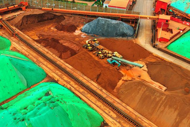 Engineering machinery organizes and loads imported iron ore at the ore terminal of Qingdao Port in Shandong province, eastern China, on July 27, 2026. (Photo by CN-STR / AFP) / China OUT