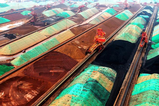 Engineering machinery organizes and loads imported iron ore at the ore terminal of Qingdao Port in Shandong province, eastern China, on July 27, 2026. (Photo by CN-STR / AFP) / China OUT