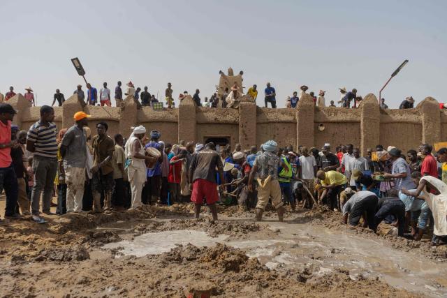 Residents collect mud during the replastering of the Sankore Mosque, as part of an event marking its 600th anniversary, in Timbuktu, on July 26, 2026. Hundreds gathered in the historic city of Timbuktu to replaster the Sankore Mosque as part of celebrations marking its 600th anniversary. Built in the 14th century, it is one of Timbuktu's three great mosques, alongside Djingareyber and Sidi Yahia. Together, they are unique examples of earthen architecture and played an important role in the early spread of Islam in Africa. The Sankore Mosque, along with the other historic mosques of Timbuktu, was inscribed on UNESCO's World Heritage List in 1988. (Photo by AFP)