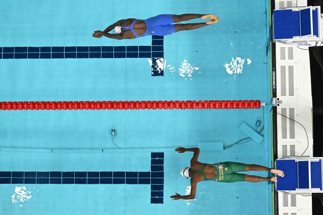Uganda's Namutebi Kirabo (L) and Solomon Islands' Loise Bently compete in the Women's 50m Breaststroke heats at the swimming event at the Tollcross International Swimming Centre in Glasgow, on day four of the Commonwealth Games in Glasgow, Scotland, on July 27, 2026. (Photo by Oli SCARFF / AFP)