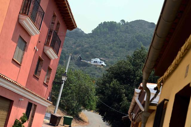 A firefighting helicopter takes off after scooping water in the evacuated town of Chovar, 60 kilometres north of Valencia, to use it against the wildfires ravaging the area. Spain faces two crucial days to bring raging wildfires under control before weather conditions worsen, authorities said on July 27, 2026, though they were making some progress and planned to start returning evacuees to certain areas. The fires in the Iberian country have affected an area of 77,000 hectares (190,000 acres) -- nearly the size of New York City -- according to the authorities. Since the start of the year, fires in Spain have ravaged 150,000 hectares and killed 13 people. (Photo by Jose JORDAN / AFP)