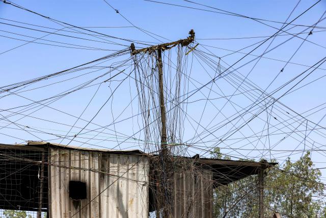Electrical wires extend from a privately-owned power generator in Baghdad's eastern Sadr City suburb on July 27, 2026. In oil-rich Iraq, many households have just a few hours of state electricity per day, and those who can afford it use private generators to keep fridges and air conditioners running. The country is the second-largest oil producer in the OPEC cartel, but despite its immense oil and gas reserves, it remains dependent on imports to meet its electricity needs. (Photo by AHMAD AL-RUBAYE / AFP)