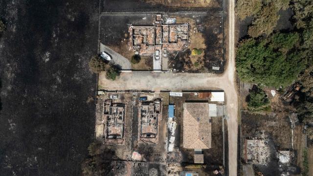 This aerial view shows damaged houses in a burnt area in the town of Le Porge, following a wildfire in the Gironde Department, south-western France, on July 27, 2026. After several days of uninterrupted spread of the massive wildfire on the outskirts of Bordeaux, the situation remained generally stable overnight from July 26 to 27, but authorities are concerned about the arrival of a heat wave. (Photo by Ed JONES / AFP)