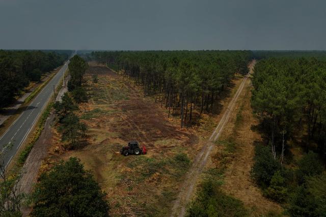 TOPSHOT - This aerial view shows a fire line, a break in vegetation, near Marcheprime, west of Bordeaux, on July 27, 2026, during wildfires in the Gironde region, southwestern France. Firefighters battled massive blazes tearing through forests across France on July 27, as authorities warned of a fresh heatwave set to engulf the scorched French wine-growing region around the major city of Bordeaux. (Photo by Philippe LOPEZ / AFP)