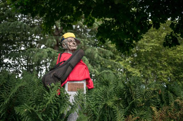 TOPSHOT - This photograph shows a bust of former Switzerland's president Jean-Pascal Delamuraz decked out with a cap, a T-shirt and a guitar case on the quay that bears his name, in Lausanne, on July 26, 2026. (Photo by Fabrice COFFRINI / AFP)