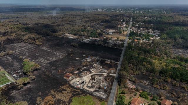 This aerial view shows damaged houses in a burnt area in the town of Le Porge, following a wildfire in the Gironde Department, south-western France, on July 27, 2026. After several days of uninterrupted spread of the massive wildfire on the outskirts of Bordeaux, the situation remained generally stable overnight from July 26 to 27, but authorities are concerned about the arrival of a heat wave. (Photo by Ed JONES / AFP)