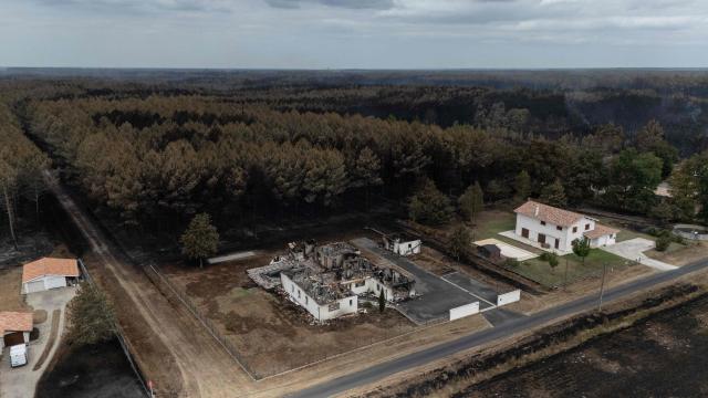 This aerial view shows a damaged house in a burnt area in the town of Le Temple, following a wildfire in the Gironde Department, south-western France, on July 27, 2026. After several days of uninterrupted spread of the massive wildfire on the outskirts of Bordeaux, the situation remained generally stable overnight from July 26 to 27, but authorities are concerned about the arrival of a heat wave. (Photo by Ed JONES / AFP)