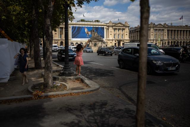A woman hails a taxi at Place de la Concorde in Paris on July 27, 2026. (Photo by Guillaume BAPTISTE / AFP)