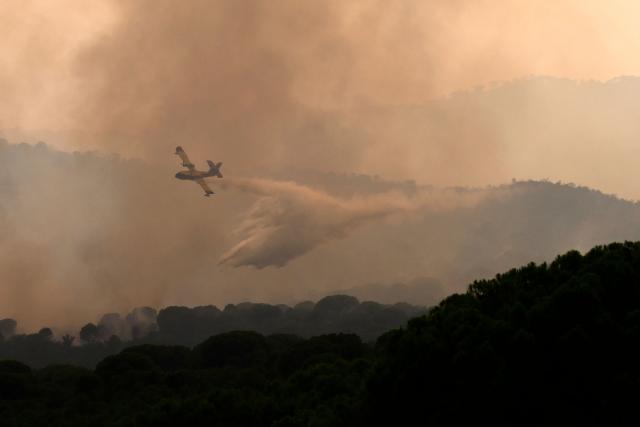 A firefighter airplane drops water on a wildfire near the village of Cebreros, Avila province, Spain, on July 27, 2026. Spain faces two crucial days to bring raging wildfires under control before weather conditions worsen, authorities said on July 27, 2026, though they were making some progress and planned to start returning evacuees to certain areas. The fires in the Iberian country have affected an area of 77,000 hectares (190,000 acres) -- nearly the size of New York City -- according to the authorities. Since the start of the year, fires in Spain have ravaged 150,000 hectares and killed 13 people. (Photo by MIGUEL RIOPA / AFP)