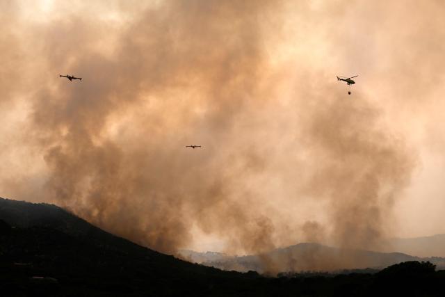 Firefighter airplanes drop water on a wildfire near the village of Cebreros, Avila province, Spain, on July 27, 2026. Spain faces two crucial days to bring raging wildfires under control before weather conditions worsen, authorities said on July 27, 2026, though they were making some progress and planned to start returning evacuees to certain areas. The fires in the Iberian country have affected an area of 77,000 hectares (190,000 acres) -- nearly the size of New York City -- according to the authorities. Since the start of the year, fires in Spain have ravaged 150,000 hectares and killed 13 people. (Photo by MIGUEL RIOPA / AFP)