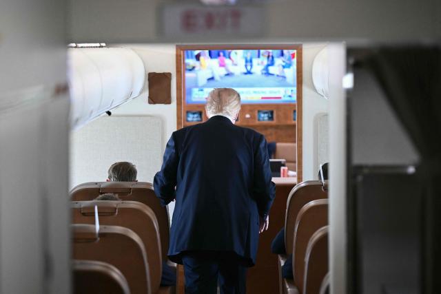 US President Donald Trump walks away after speaking to the press on board Air Force One, in the air en route to Michigan, on July 27, 2026. Trump is traveling to Milford, Michigan to deliver remarks at General Motors’ vehicle testing site Milford Proving Ground. (Photo by Brendan SMIALOWSKI / AFP)