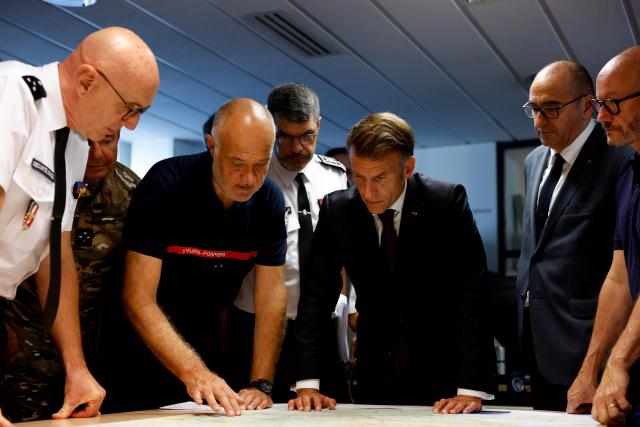 France's President Emmanuel Macron (C) and France's Interior Minister Laurent Nunez (2R)  listen to SDIS 33 Fire and Rescue Service Departemental director Marc Vermeulen (2L) during a situation briefing in the crisis room at the Departmental Fire and Rescue Operational Center (CODIS) in Bordeaux, following wildfires in the area, southwestern France, on July 27, 2026. France has been battered by three heatwaves since May as part of increasingly common extreme weather episodes linked to climate change, causing excess deaths, drying up rivers and fuelling wildfires. Scientists have long warned that climate change caused by human use of fossil fuels will make periods of drought more intense and longer-lasting, creating the ideal conditions for wildfires. (Photo by Kenzo TRIBOUILLARD / POOL / AFP)