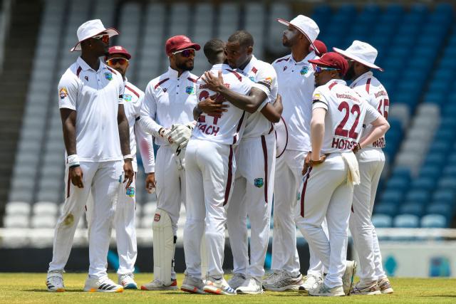 Teammates watch as Kemar Roach (3L) congratulates Justin Greaves (4R) of West Indies for his 5-wicket haul during the third day of the first Test cricket match between West Indies and Pakistan at the Brian Lara Cricket Academy in Tarouba, Trinidad and Tobago, on July 27, 2026. (Photo by Randy Brooks / AFP)