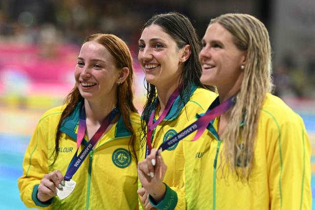 Silver medallist Australia's Mollie O'Callaghan (L), gold medallist Australia's Meg Harris (C) and bronze medallist Australia's Shayna Jack celebrate during the Women's 100m Freestyle Medal Ceremony at the swimming event at the Tollcross International Swimming Centre in Glasgow, on day four of the Commonwealth Games in Glasgow, Scotland, on July 27, 2026. (Photo by Oli SCARFF / AFP)